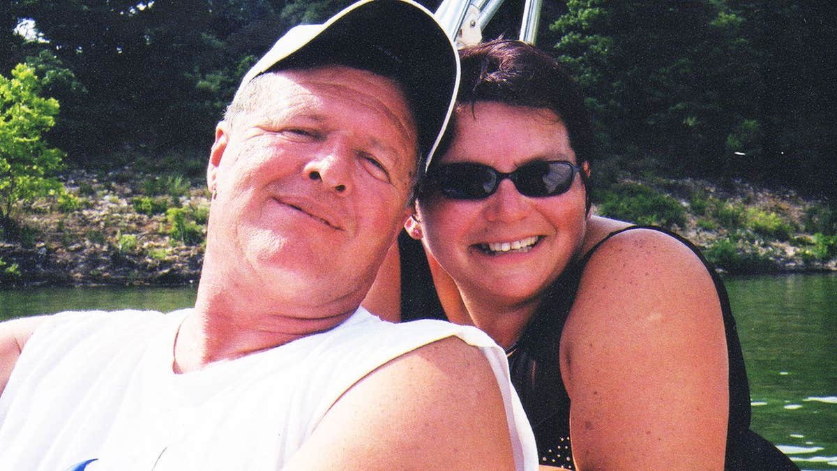 Jeff Walton wearing a white tank top leaning against a smiling Deb Proctor in a black tank top.