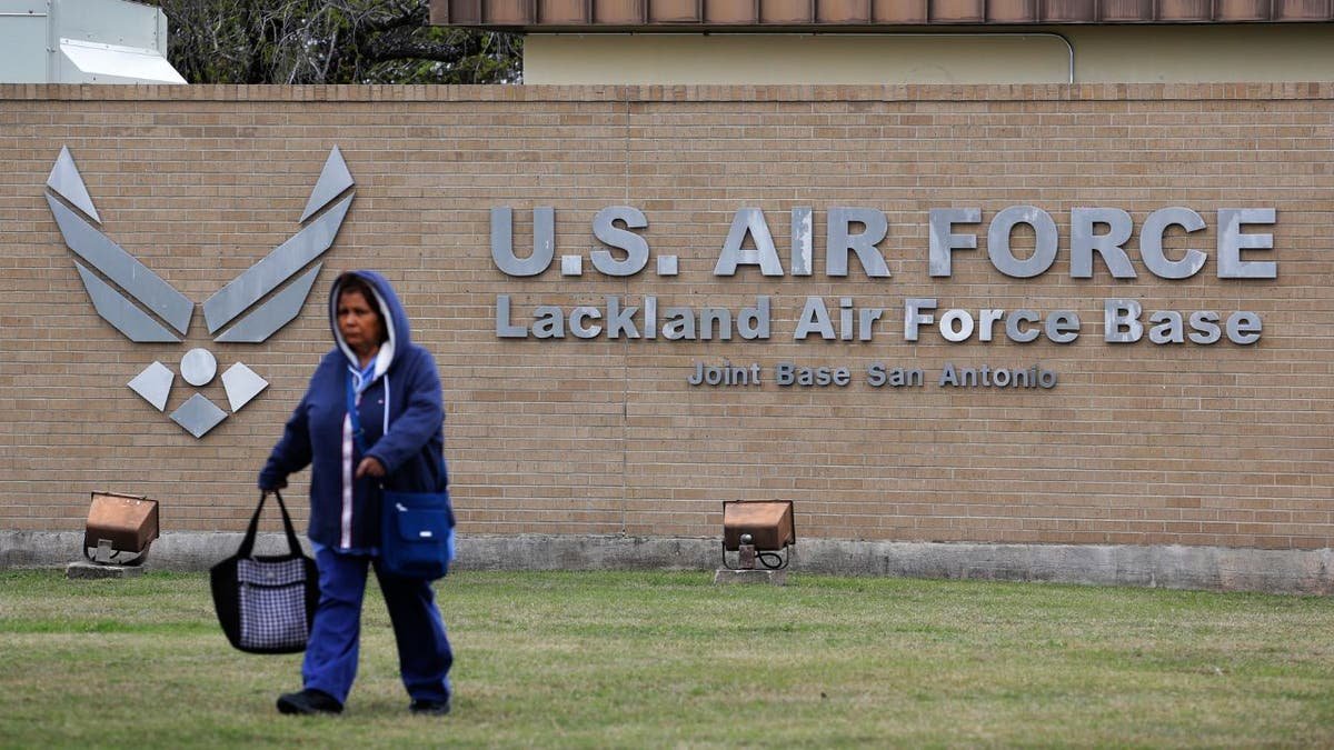 A pedestrian walking past the main gate at Lackland Air Force Base in San Antonio