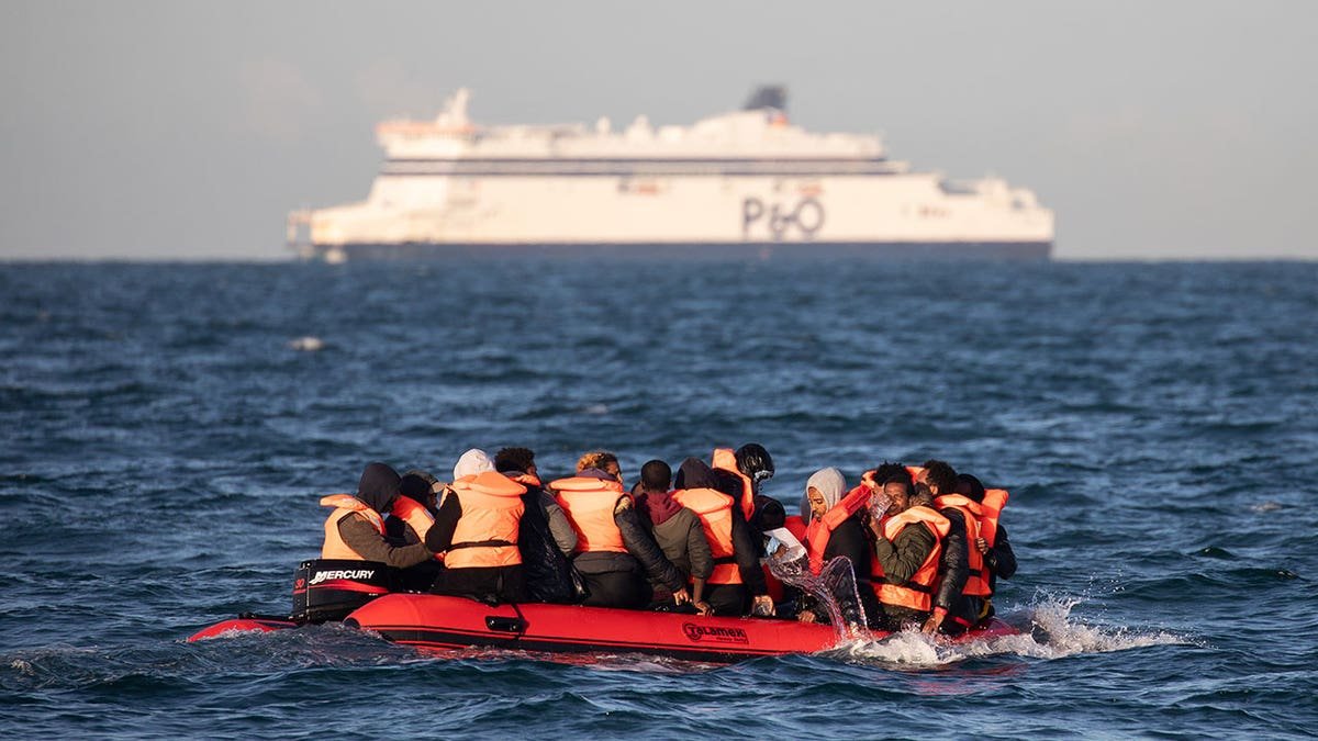 Migrants bailing water from a small inflatable boat near Dover Strait