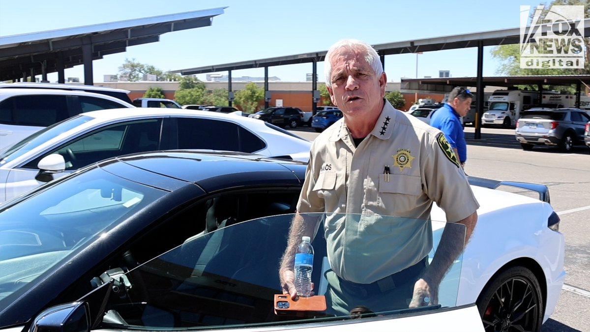 Pima Sheriff Chris Nanos in uniform entering his white Corvette at the PCSD HQ in Tucson