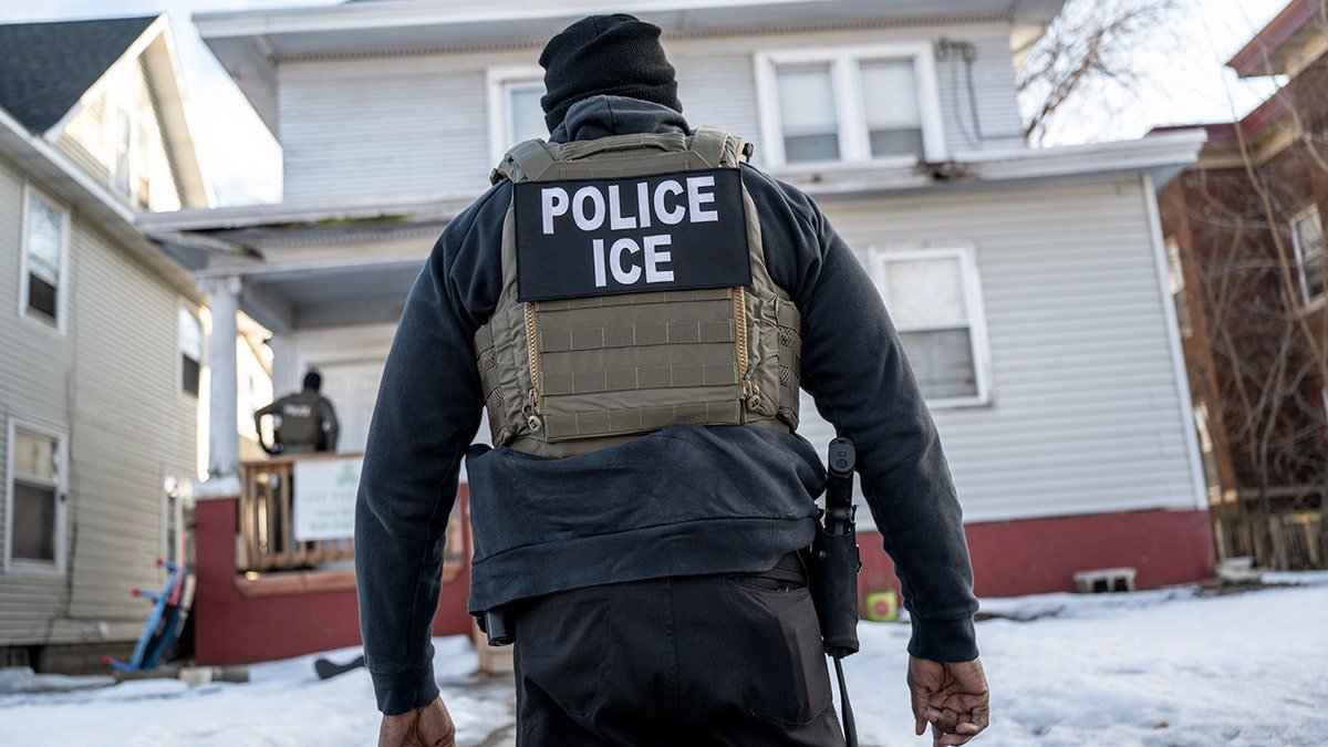 Agent with "POLICE ICE" sign on their vest