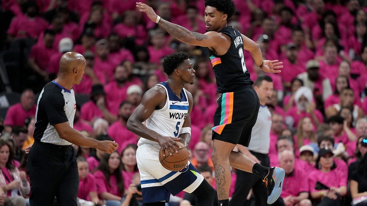 Minnesota Timberwolves guard Anthony Edwards dribbling basketball defended by San Antonio Spurs guard Dylan Harper