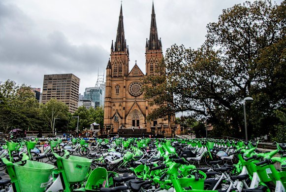 Lime bikes parked in a fenced-off area in front of St Mary’s Cathedral near Hyde Park.