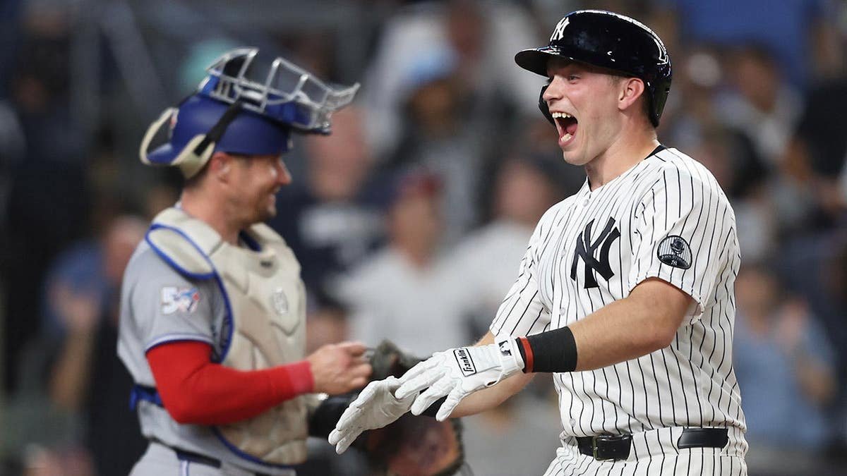 New York Yankees' Ben Rice reacting at home plate after hitting a home run.