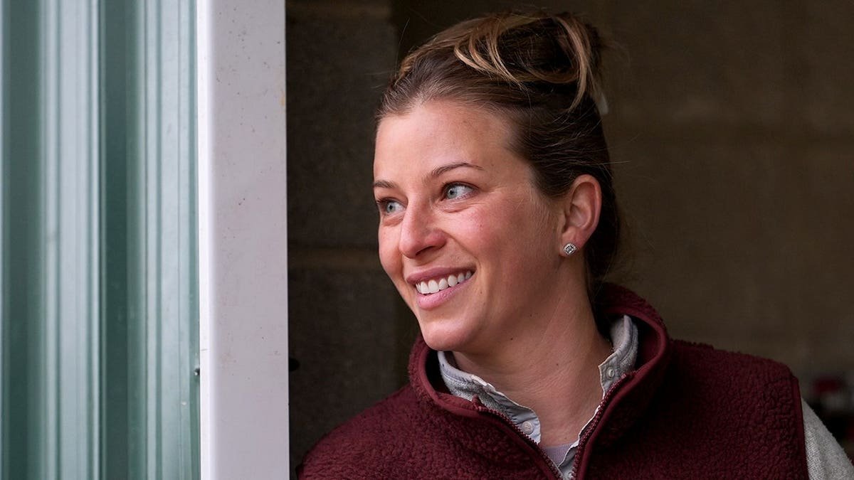 Trainer Brittany Russell talking to people in a barn at Laurel Park