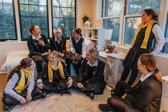 Year 7 and year 11 students gather in a dorm at Abbotsleigh. 