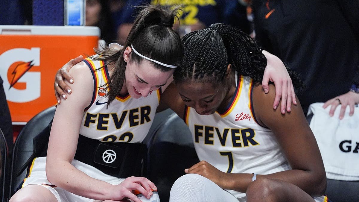 Indiana Fever guard Caitlin Clark and center-forward Aliyah Boston sharing a moment on basketball court