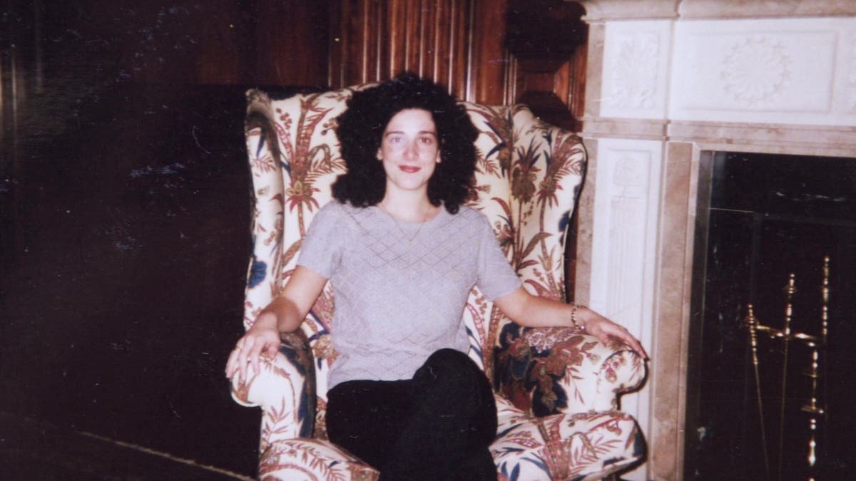 Chandra Levy sitting indoors beside a fireplace in an undated family photo