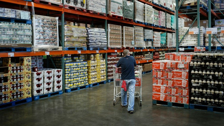 shopper pushing cart through aisle at costco