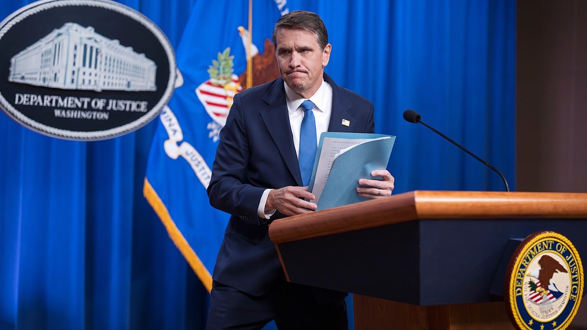 Deputy Attorney General Todd Blanche speaking at a podium inside the Department of Justice in Washington