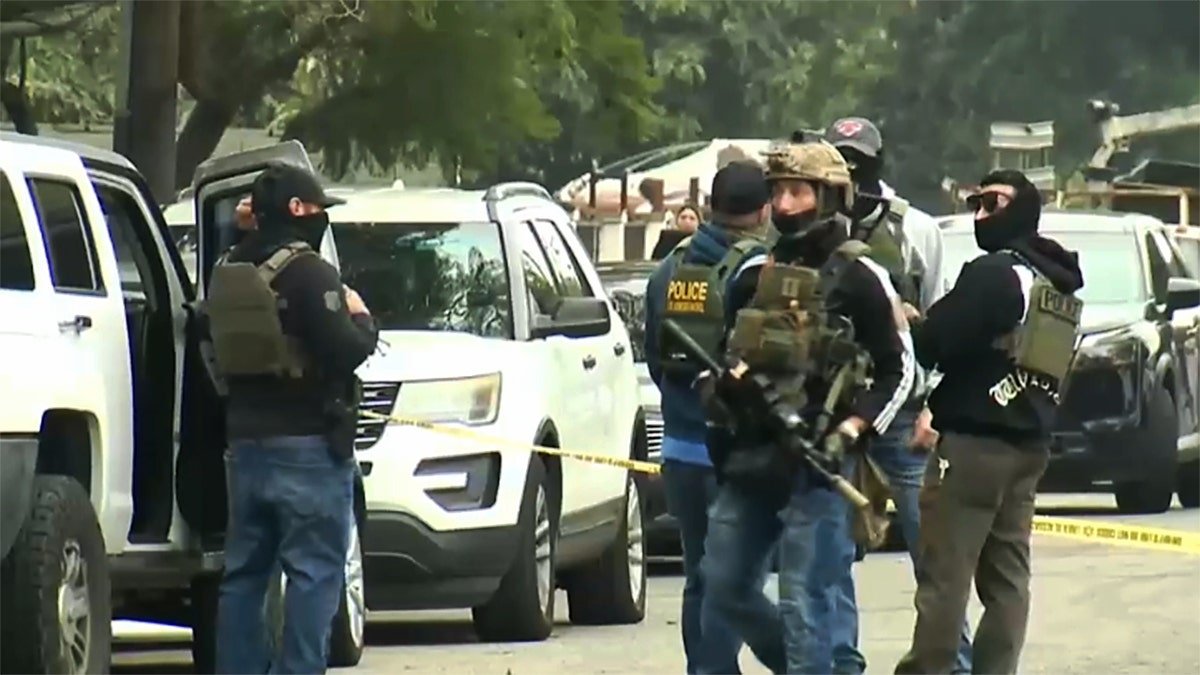 DHS officers walking near cars in a parking lot in Compton, California