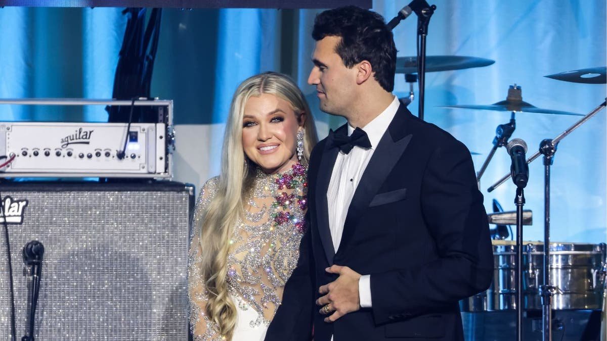 Conservative activist Charlie Kirk and his wife Erika Kirk standing on stage at an event