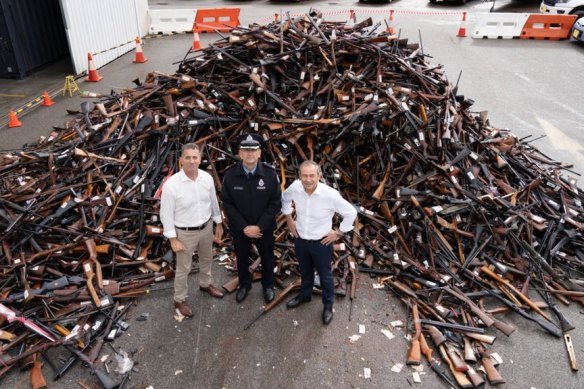 Former WA police minister Paul Papalia, Police Commissioner Col Blanch and WA Premier Roger Cook with a haul of firearms to be destroyed after a recent gun buyback.