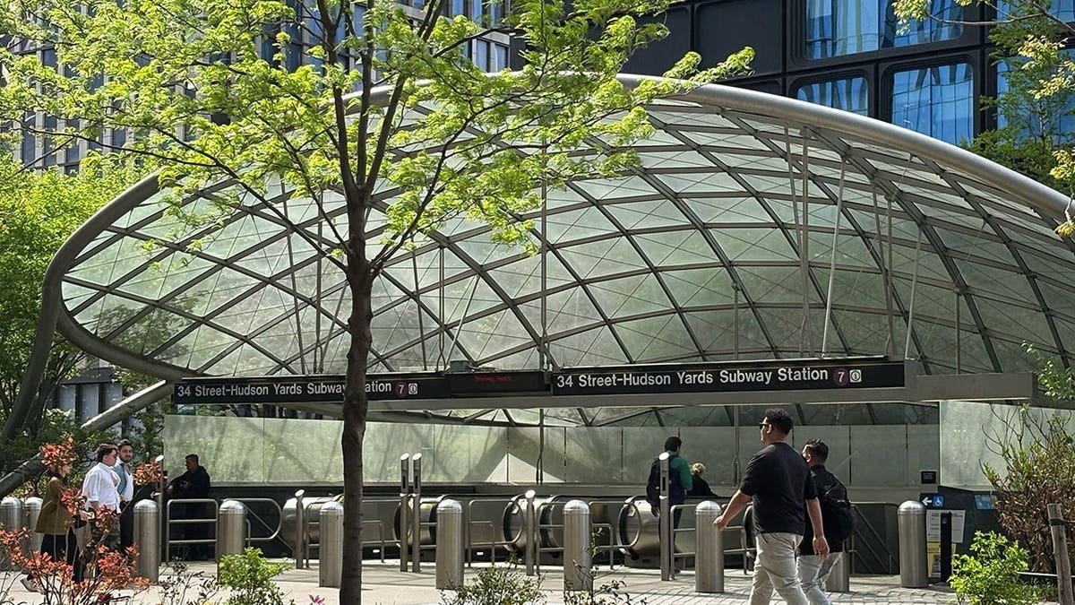 34 Street–Hudson Yards subway station entrance with glass canopy and commuters in Manhattan NYC.