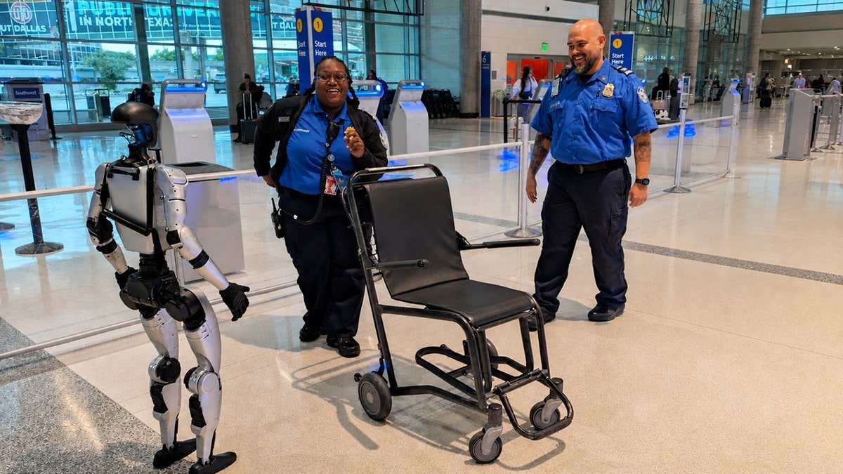 Humanoid robot and two TSA officers appear to dance near an airport security checkpoint.