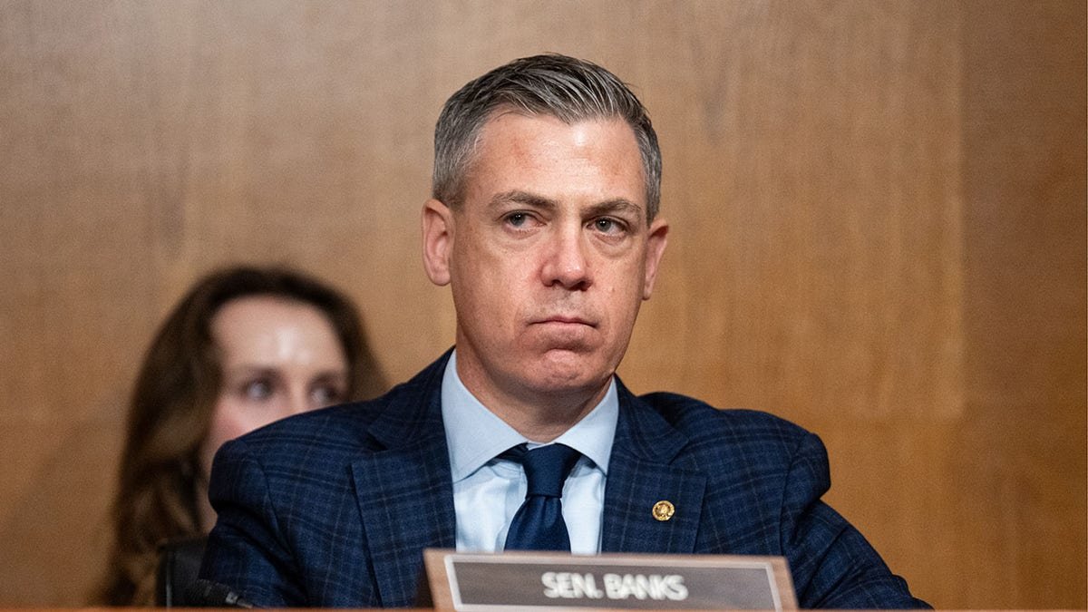 Sen. Jim Banks listening during a Senate committee confirmation hearing in a Senate office building