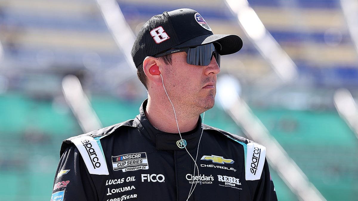 Kyle Busch standing near his #8 Nicokick x zone Cranberry Chevrolet at Kansas Speedway
