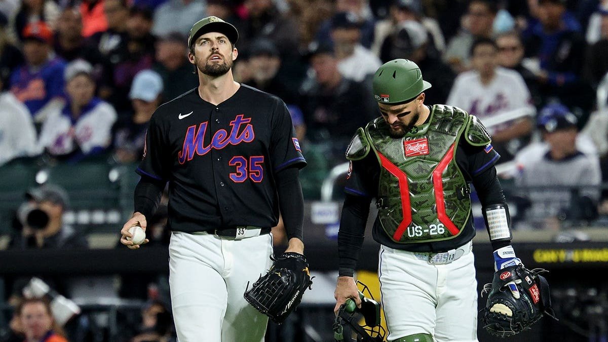 New York Mets catcher Luis Torrens looking down at pitcher Clay Holmes's leg at Citi Field