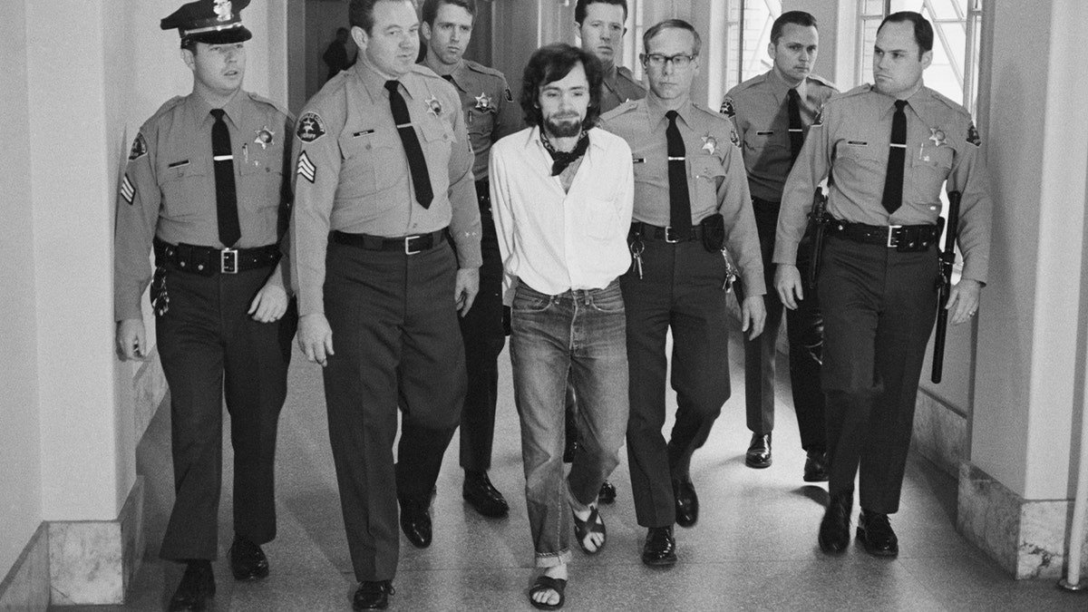 Charles Manson escorted by seven deputies in courtroom