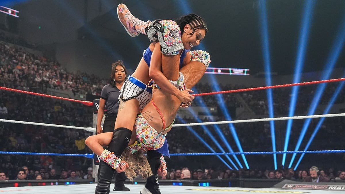 Michin performing a Styles Clash on Charlotte Flair in a wrestling ring