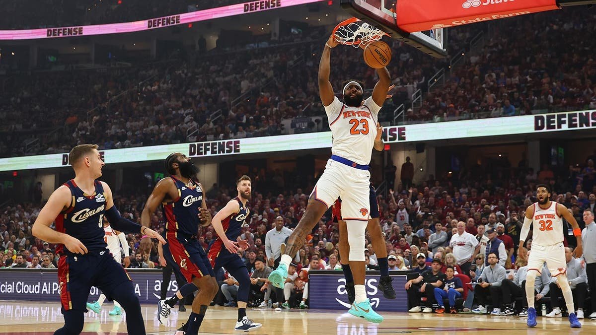 Mitchell Robinson of the New York Knicks dunks the basketball against Jaylon Tyson of the Cleveland Cavaliers.
