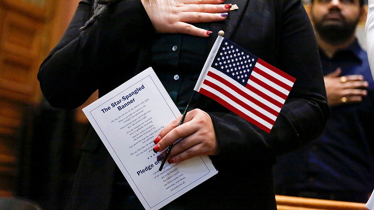 A legal migrant swearing in to become a U.S. citizen at a naturalization ceremony.