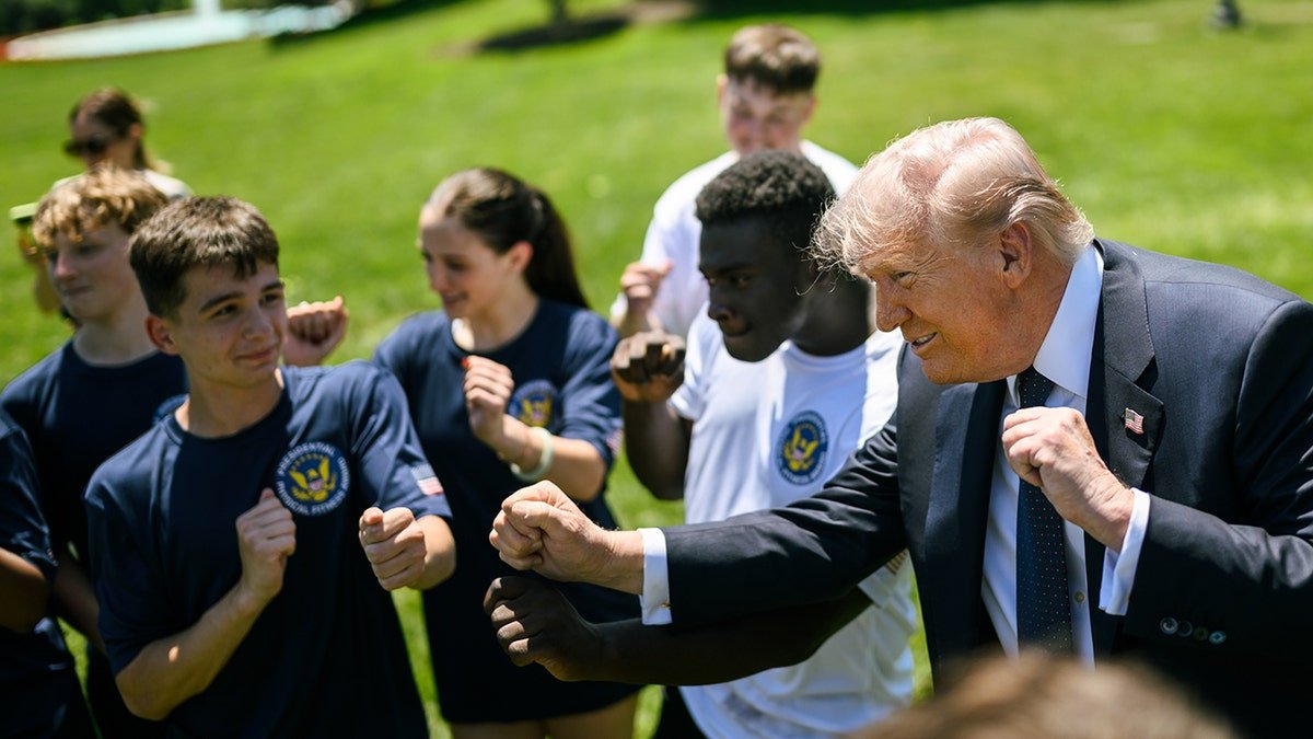 President Trump does YMCA dance move with students.
