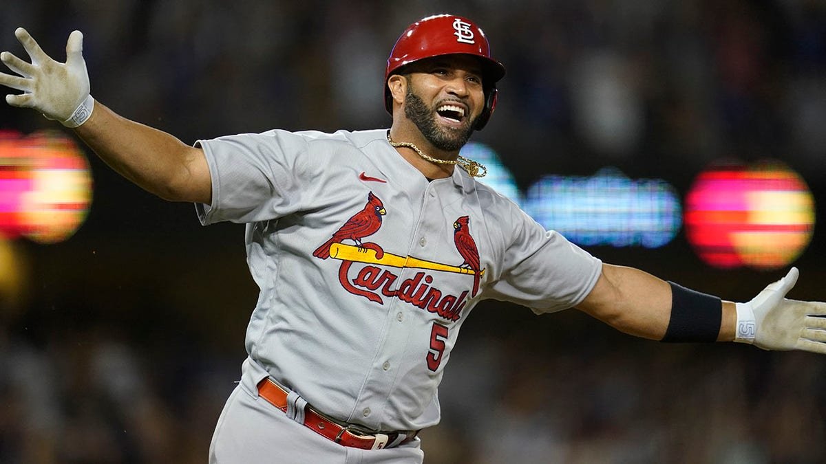 Albert Pujols watching after hitting a home run during a baseball game.