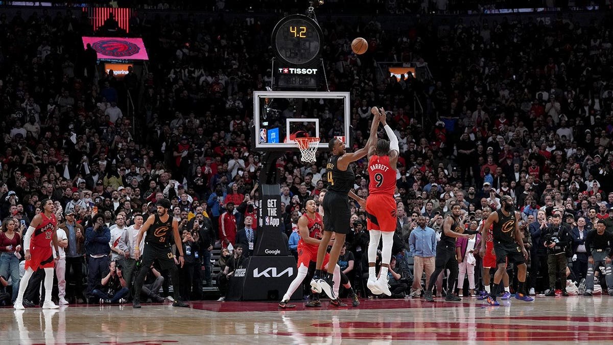 Toronto Raptors forward RJ Barrett shooting a basketball during overtime in a game.