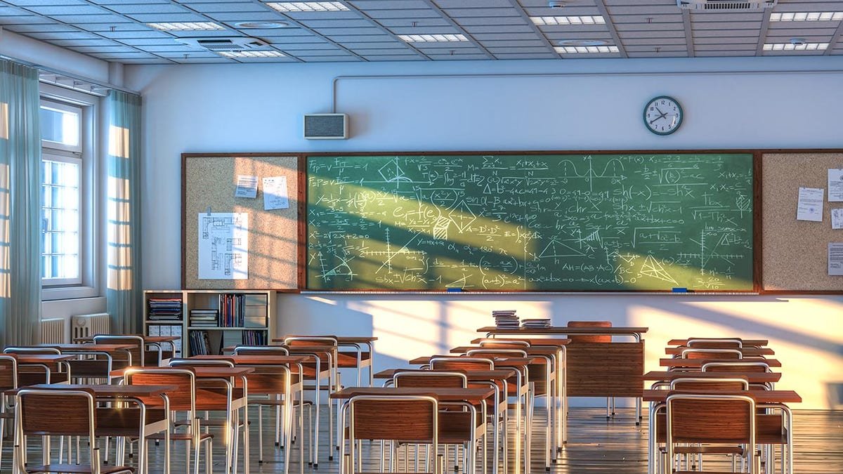 Empty school classroom with wooden desks and chairs