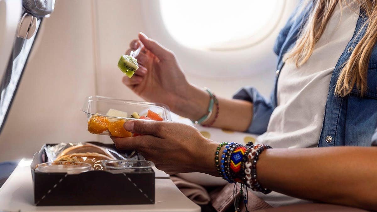 Woman enjoying a gourmet meal while seated on a flight