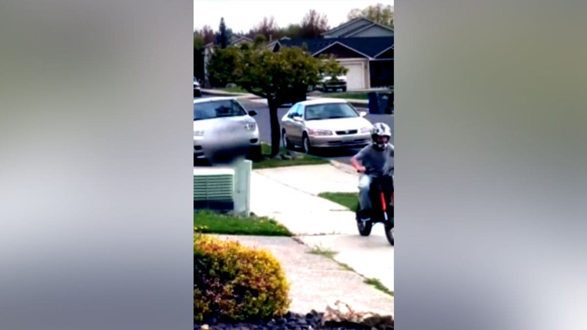 boy on dirt bike fleeing down sidewalk as car follows behind him