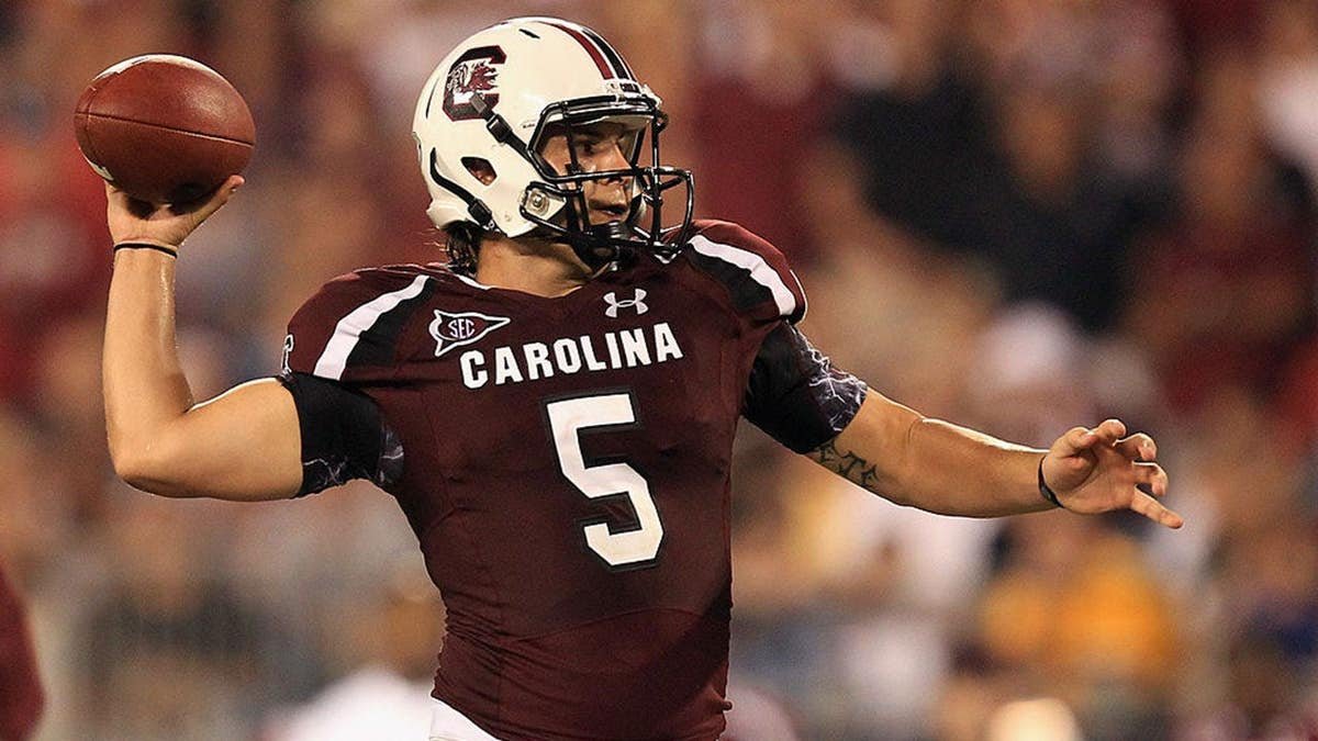 Stephen Garcia dropping back to pass during a football game at Bank of America Stadium
