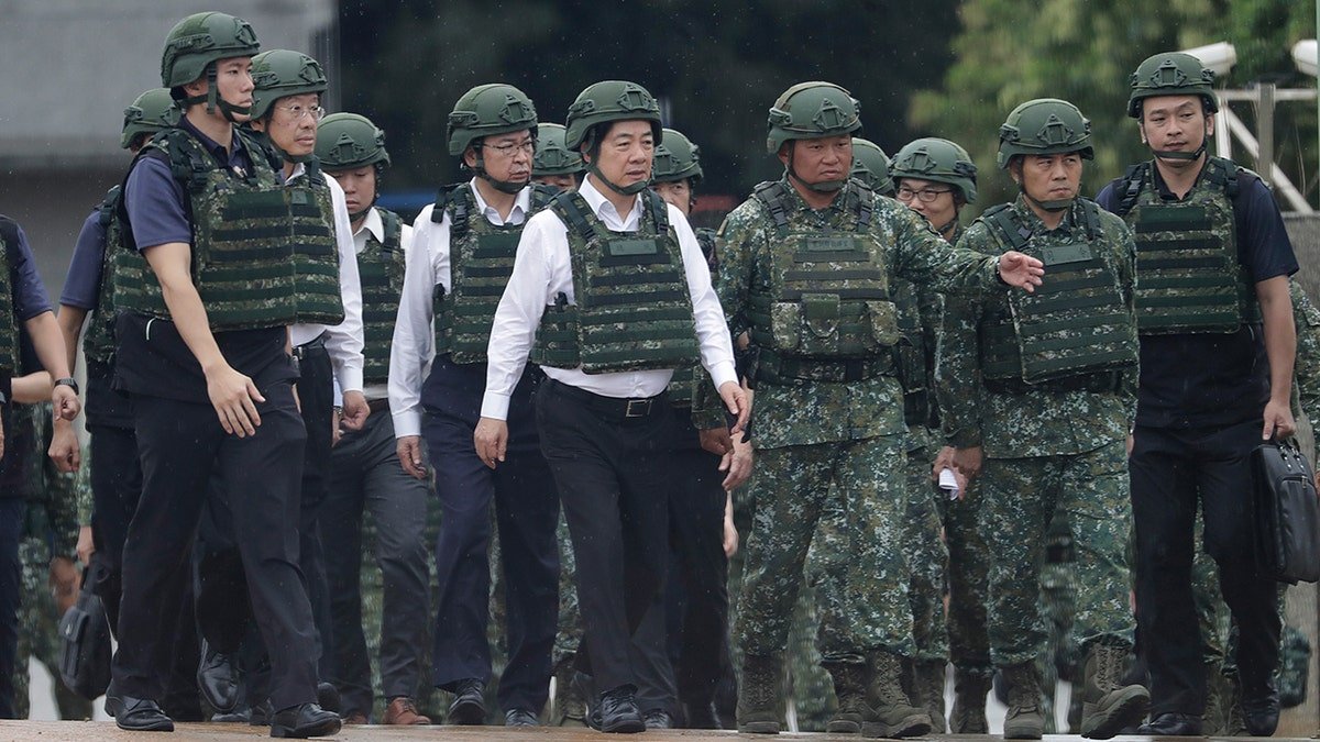 Taiwan President Lai Ching-te walking in military helmet and vest during live-fire training