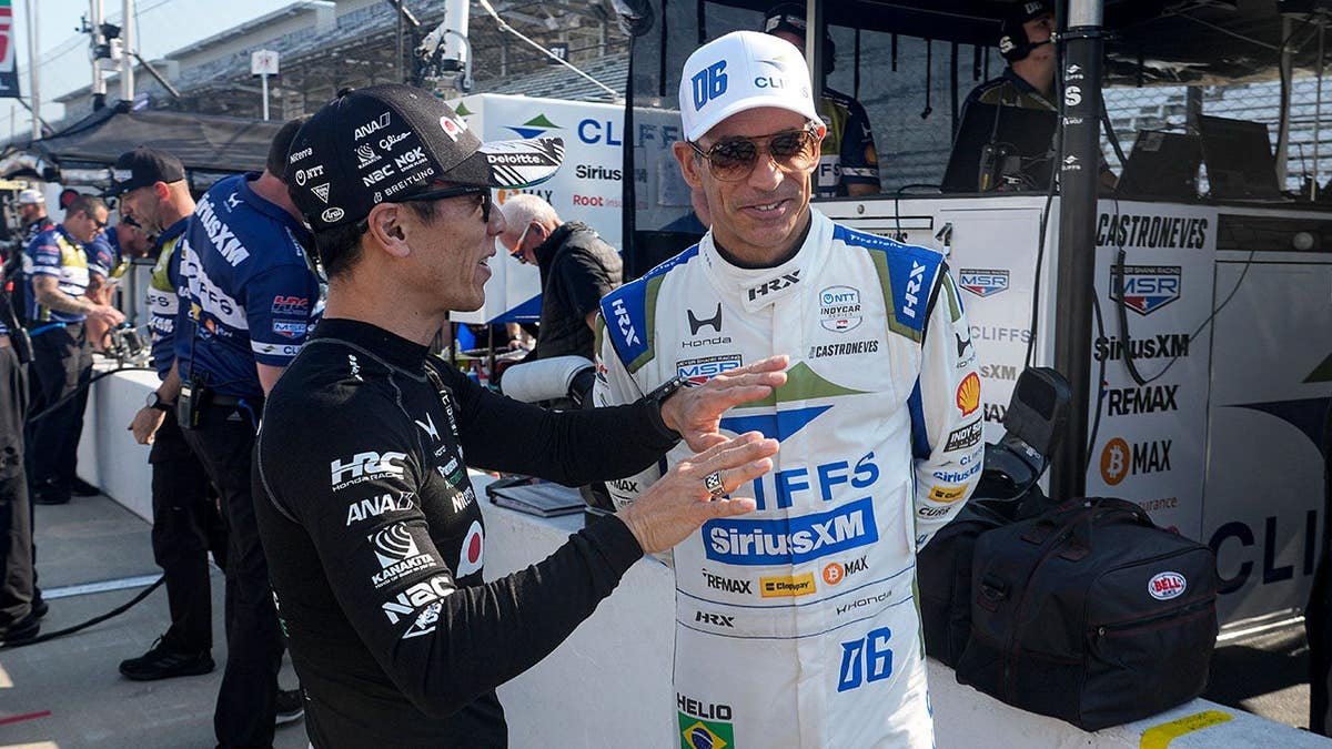 Takuma Sato and Helio Castroneves talking during practice at Indianapolis Motor Speedway