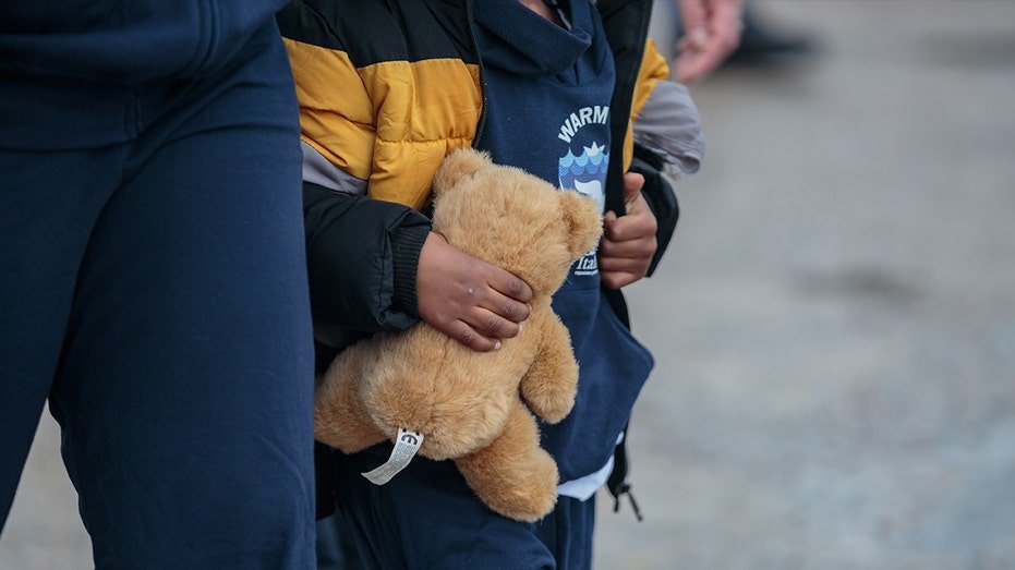 child holding a teddy bear