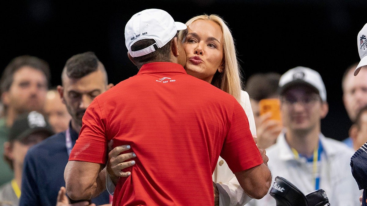 Tiger Woods receiving a hug and kiss from Vanessa Trump at SoFi Center