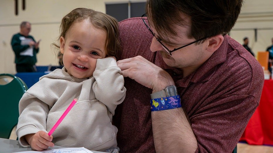 A father and daughter smile for the camera on military base