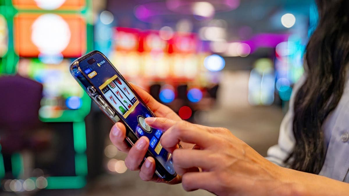 A woman plays a slot machine game on her cellphone.