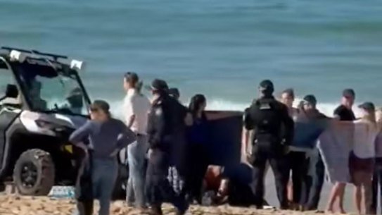 A woman is treated on Coogee Beach after being bitten by a shark.