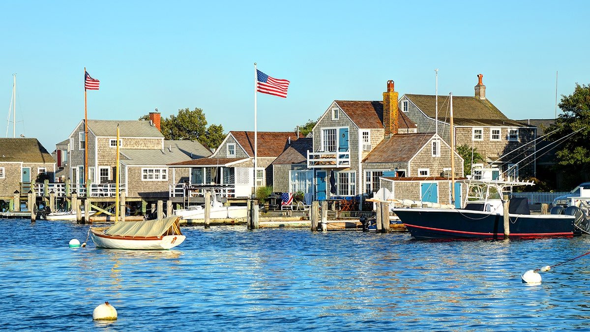 Nantucket waterfront homes with cedar shingle siding overlooking harbor with sailboats and motorboats