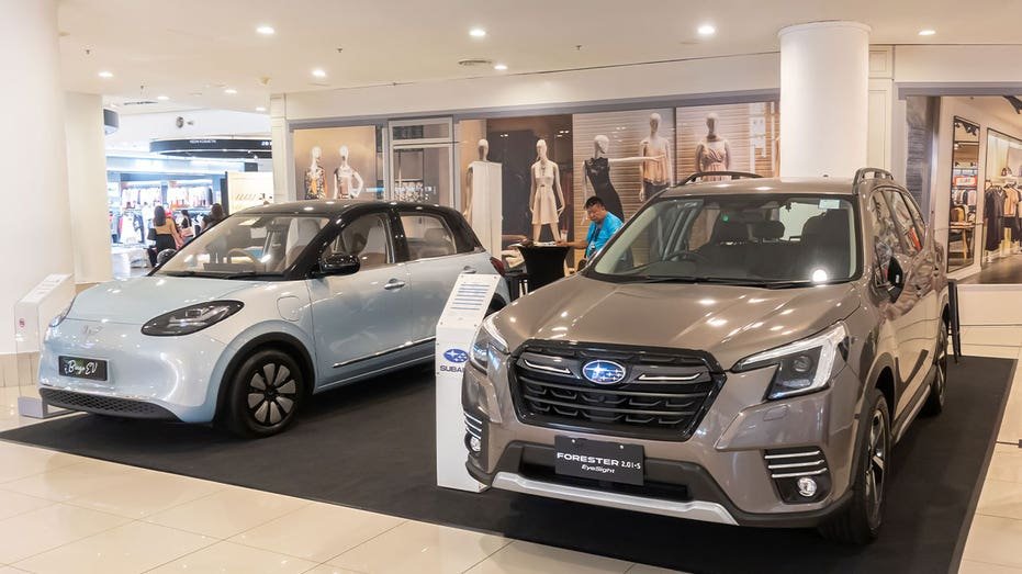 Two cars next to each other at an event: a Subaru Forester and a Wuling Bingo EV