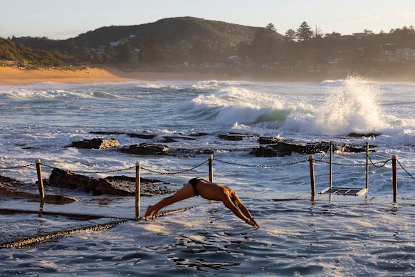 A man dives into the ocean pool.