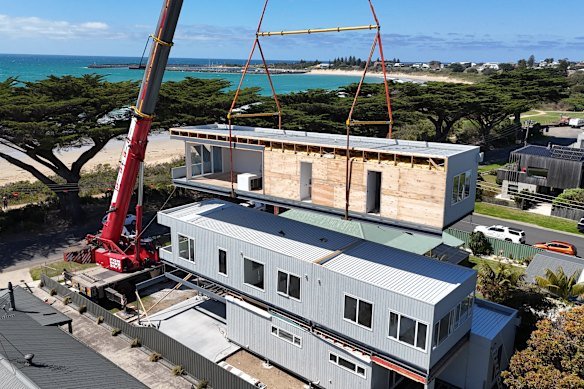 A modular home is craned into position.