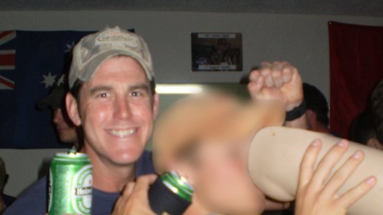 Ben Roberts-Smith (left) with a former colleague drinking from the prosthetic leg of a dead Afghan man in 2012.
