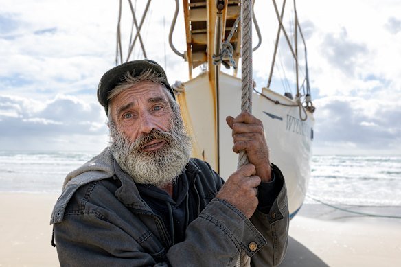 Skipper Jeff Sutton and his beached yacht Wyuna 1, north of Byron Bay. 