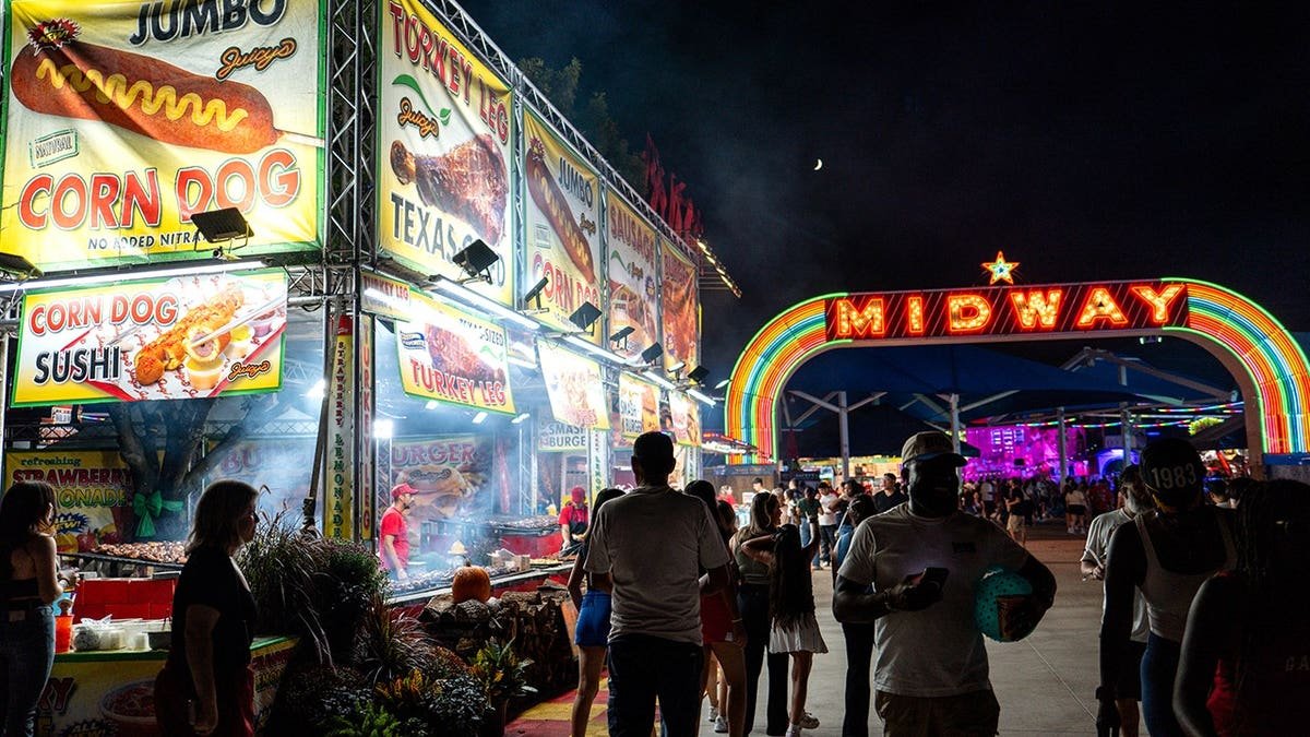People getting fried food at State Fair of Texas at night