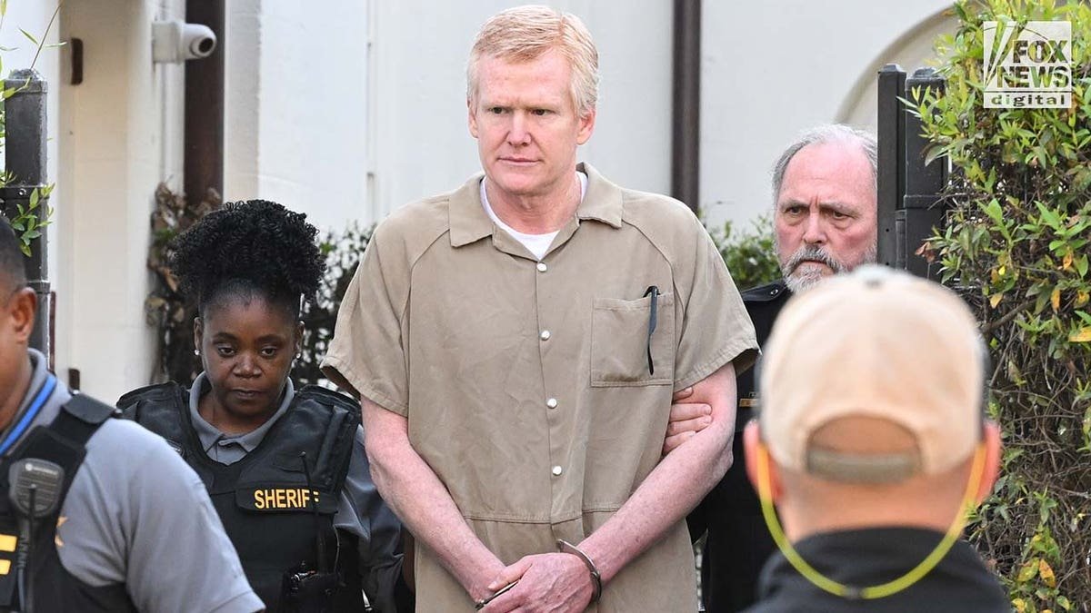 Alex Murdaugh in tan prison jumpsuit being led out of Colleton County courthouse