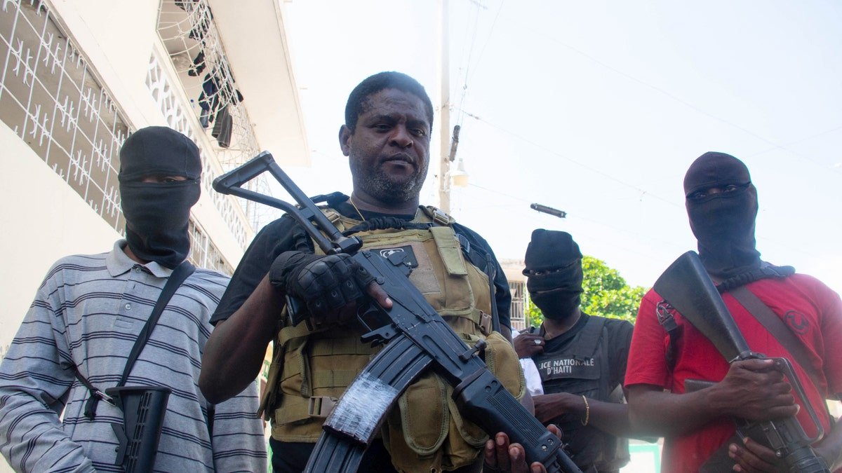Armed gang leader Jimmy Barbecue Cherizier standing with men in Port-au-Prince Haiti