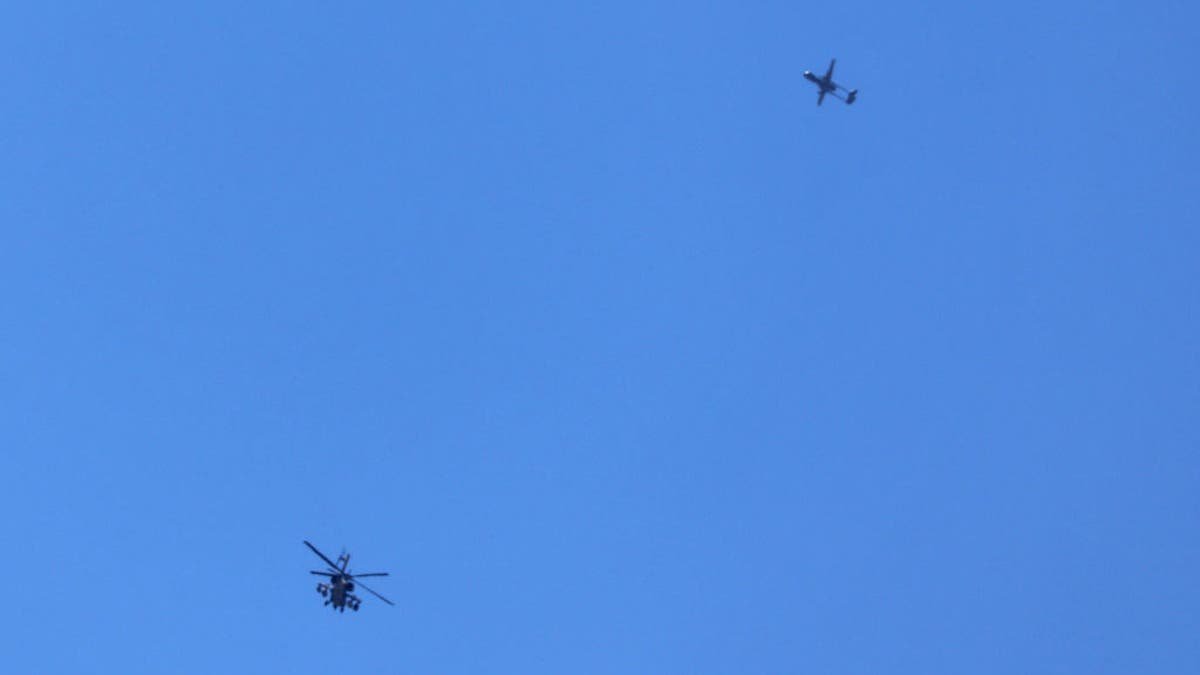An Israeli military helicopter and drone flying above the southern border area with the Gaza Strip